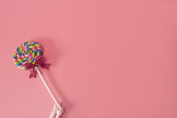 Doll hand holding colorful candy. Lollipop candy minimal creative concept