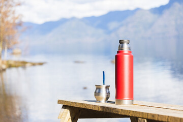 Mate and a thermo full of hot water ready to drink in a natural environment. Latin beverage.
