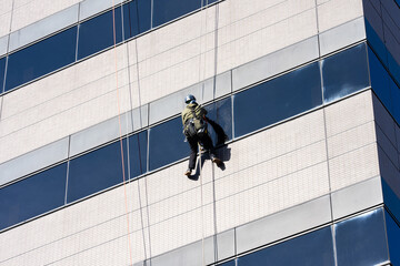 高層ビルの窓ガラスを磨く清掃員