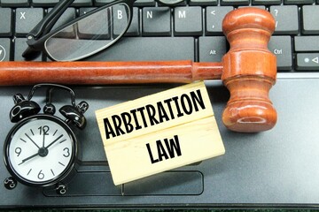 glasses, hammers, alarm clocks and wooden boards with the words arbitration law