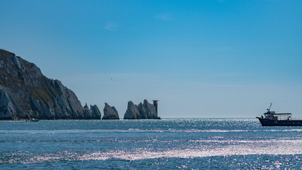 View of boat sailing next to the Needles, in Alum bay, Isle of Wight, United Kingdom