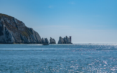 Far away view ofboat sailing next to the Needles, in Alum bay, Isle of Wight, United Kingdom