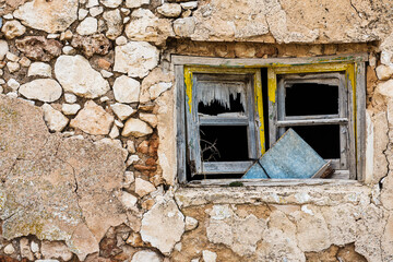 Broken wooden window in a stone wall