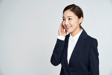 Young telemarketer business woman posing in studio shot
