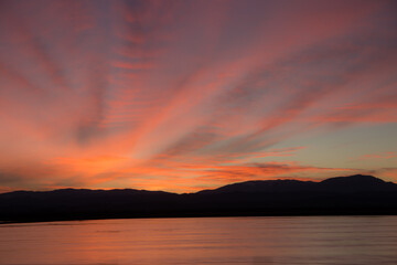 Orange sunset and clouds with reflection on water