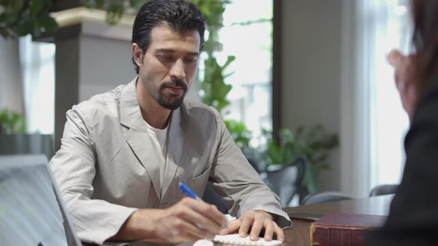 couple talking and working with laptop computer together in office.  business woman take note from discussion with customer. lawyer Write a message from a conversation with desperate client . stressed