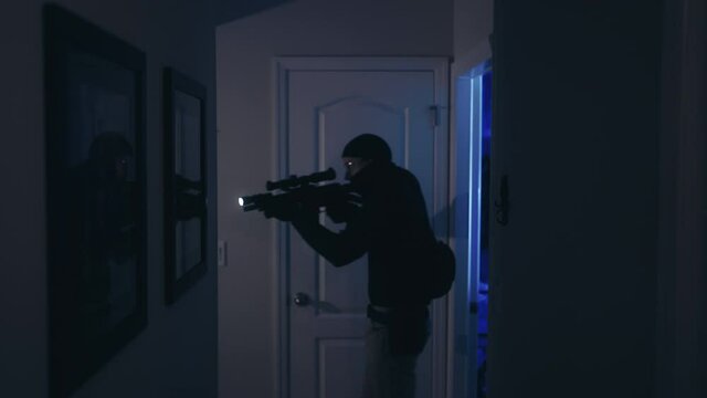 Cinematic shot of a police raid with flashing lights and a SWAT officer entering house.