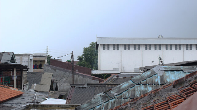 photo of a building taken on the roof when the sky is cloudy in a densely populated area of Jakarta, Indonesia