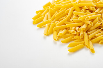 Raw dry penne pasta on white background.
Italian food penne pasta image for background.
