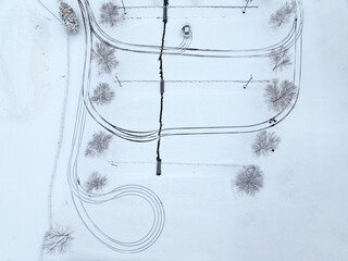 aerial view of parking lot after snow with tree and track
