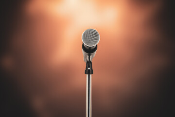 Microphone with stage light background for performance concept of speech comment and public speaking