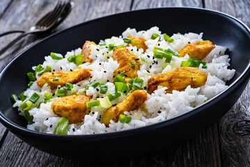 Chicken nuggets with rice and vegetables on wooden table
