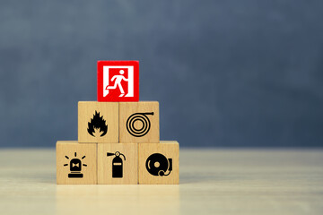 Wooden block stack with fire prevention icon with door exit and fire extinguisher and emergency protection symbol for safety. - obrazy, fototapety, plakaty