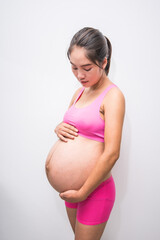 Pregnant woman in pink underwear. Young woman expecting a baby.