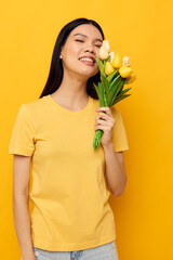 Portrait Asian beautiful young woman bouquet of flowers in hands spring fun posing yellow background unaltered