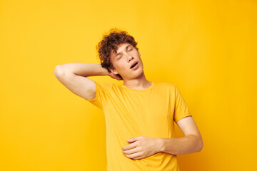 portrait of a young curly man yellow t-shirt fashion hand gestures isolated background unaltered