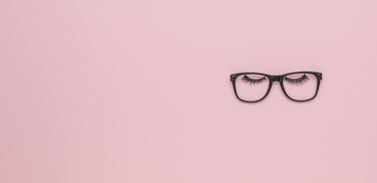 Black Glasses And Big Black Eyelashes On A Pink Background. Minimalism.