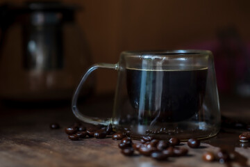 Coffee in cup on wooden table with natural light blur background