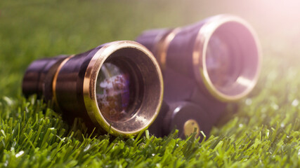 Retro theatrical binoculars on the grass in the park