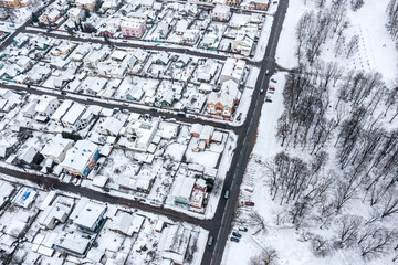aerial view of cityscape with snow-covered traditional housing estate in the suburbs in wintertime