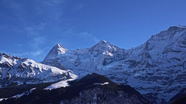 Swiss Alps at Bernese Highlands with famous peaks Eiger, Monk and Virgin on a sunny winter day. Movie shot January 15th, 2022, Lauterbrunnen, Switzerland.