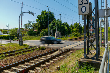 Beschrankter Bahnübergang KFZ Auto überquert Gleise Gleisbereich Schranke am Bahnhof geöffnet...