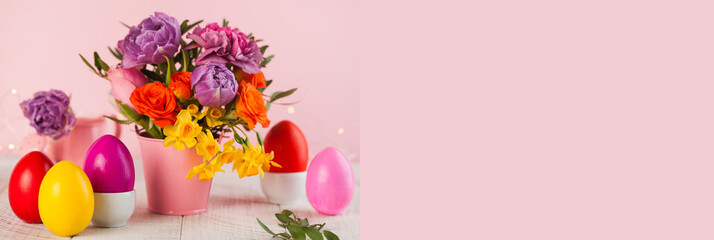 Easter card. Colorful Easter eggs on the background of a bouquet of flowers. Copy space.