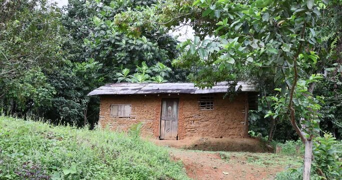 Mud home poor poverty rural bush village Liberia. Villages far from modern society in the remote bush of West Africa. Homes built using mud, sticks, thatch roofs. Poor poverty society and culture.