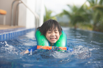 Asian child swiming in the pool in summer