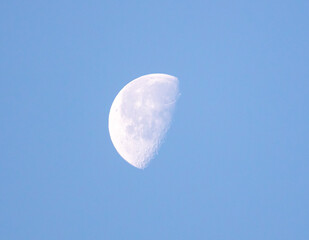 The moon against the blue sky.