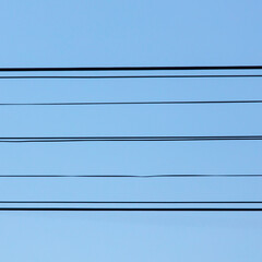 Electric wires against a blue sky.