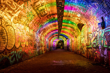 illuminated tunnel for pedestrians painted with graffiti