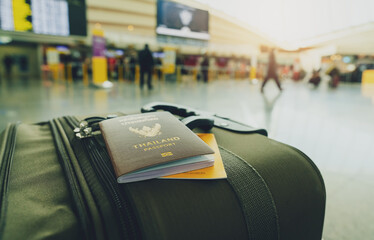Thailand passport and vaccine passport on baggage on blur background of tourist in the airport....