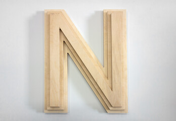 A three-dimensional letter N made of wood on a white isolate. The letter is made of plywood.