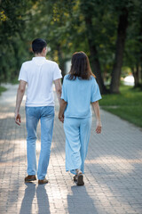 Obraz premium Man and woman walking along a path in a summer park.