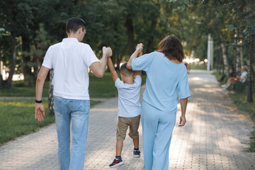 Family couple with son in summer park.