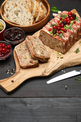 Traditional French terrine covered with bacon on dark wooden background