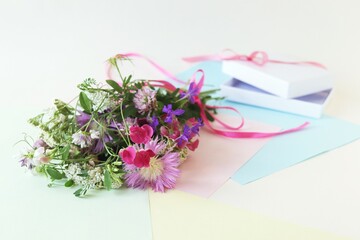 Bouquet of fresh wildflowers on a light background, the concept of a romantic greeting, invitation, wedding, postcard, Valentine's Day or sale in a flower shop