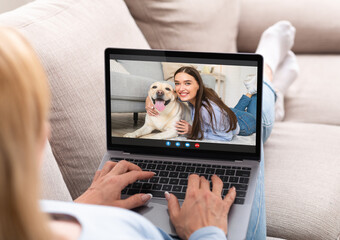 Unrecognizable Lady Having Video Call With Female Friend While Relaxing On Couch