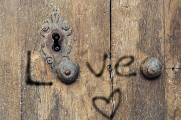 Rustic wooden door with a painted sign saying love and a heart