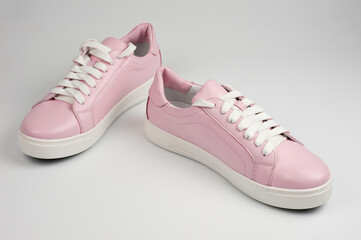 Light pink faux leather shoes laced with laces. Close-up shot.