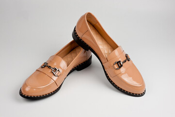 Beige patent leather leatherette shoes with buckle. Close-up shot.