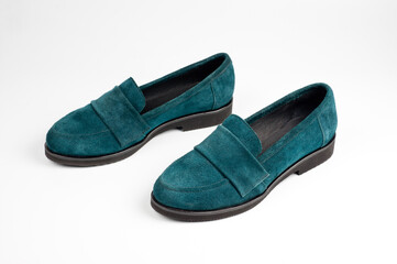 Suede dark green women's slip-on shoes with a small heel. Close-up shot.