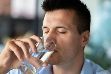 Fototapeta na wymiar Portrait young caucasian man enjoy from drinking clean fresh water
