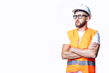Young man with a beard in casual clothes, crossing his arms on a light background.