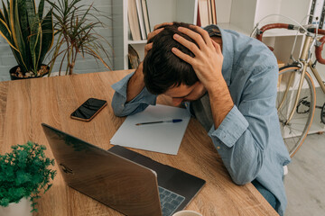 man with problems or stress at the desk with computer