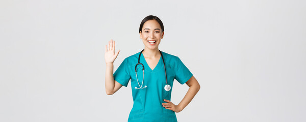 Covid-19, healthcare workers and preventing virus concept. Friendly-looking smiling asian female...