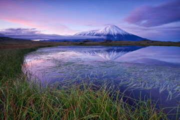 Tolbachik volcano reflecing in small lake. August sunrise. Kamchatka, Russia