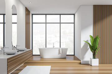 Bright bathroom interior with bathtub, panoramic window with town view