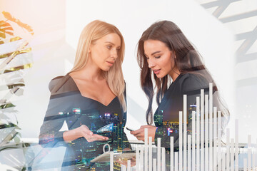 Businesswoman with tablet and phone, bar chart hologram with skyscrapers